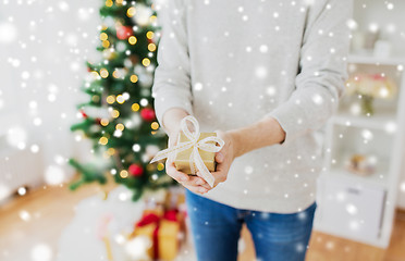 Image showing close up of man with christmas gift at home