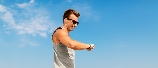 Image showing happy man looking at fitness tracker