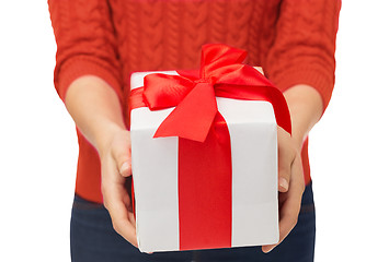 Image showing close up of woman in red sweater holding gift box