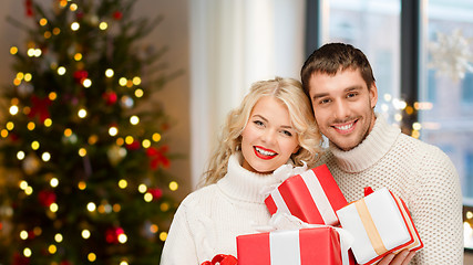 Image showing happy couple with christmas gifts at home