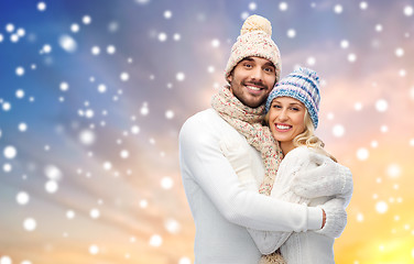 Image showing happy couple in winter clothes hugging over snow