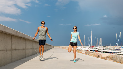 Image showing happy couple warming up on pier before training