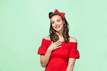 Image showing Beautiful young woman with pinup make-up and hairstyle. Studio shot on white background