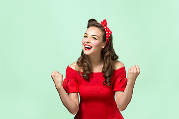 Image showing Beautiful young woman with pinup make-up and hairstyle. Studio shot on white background