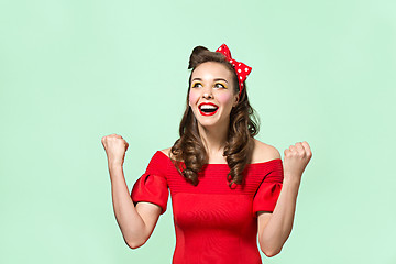 Image showing Beautiful young woman with pinup make-up and hairstyle. Studio shot on white background