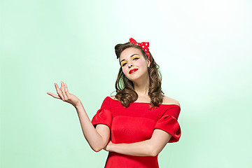 Image showing Beautiful young woman with pinup make-up and hairstyle. Studio shot on white background