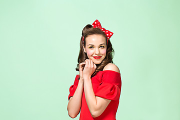 Image showing Beautiful young woman with pinup make-up and hairstyle. Studio shot on white background