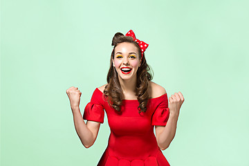 Image showing Beautiful young woman with pinup make-up and hairstyle. Studio shot on white background