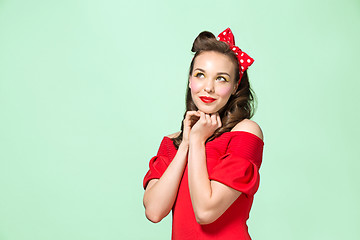 Image showing Beautiful young woman with pinup make-up and hairstyle. Studio shot on white background