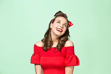 Image showing Beautiful young woman with pinup make-up and hairstyle. Studio shot on white background