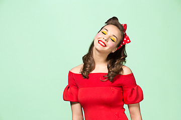 Image showing Beautiful young woman with pinup make-up and hairstyle. Studio shot on white background