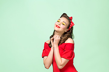 Image showing Beautiful young woman with pinup make-up and hairstyle. Studio shot on white background