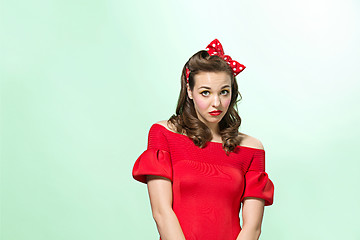 Image showing Beautiful young woman with pinup make-up and hairstyle. Studio shot on white background