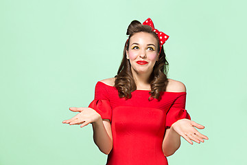 Image showing Beautiful young woman with pinup make-up and hairstyle. Studio shot on white background