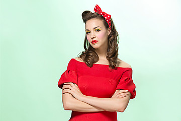 Image showing Beautiful young woman with pinup make-up and hairstyle. Studio shot on white background