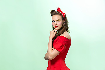 Image showing Beautiful young woman with pinup make-up and hairstyle. Studio shot on white background