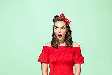 Image showing Beautiful young woman with pinup make-up and hairstyle. Studio shot on white background