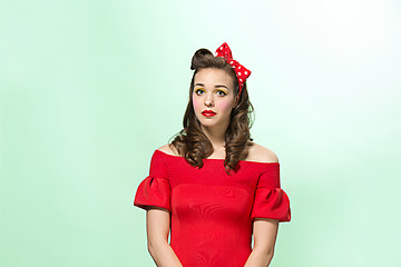 Image showing Beautiful young woman with pinup make-up and hairstyle. Studio shot on white background