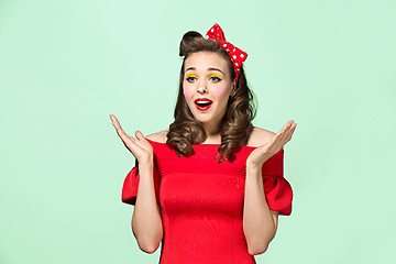 Image showing Beautiful young woman with pinup make-up and hairstyle. Studio shot on white background