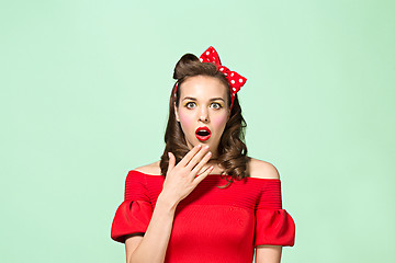 Image showing Beautiful young woman with pinup make-up and hairstyle. Studio shot on white background