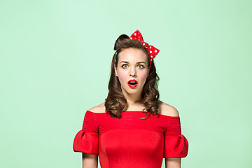 Image showing Beautiful young woman with pinup make-up and hairstyle. Studio shot on white background