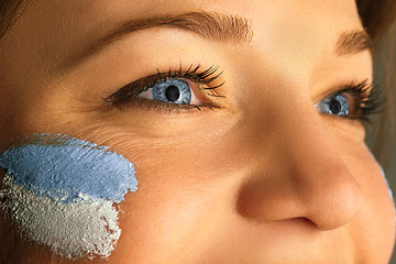 Image showing Portrait of a woman with the flag of the Argentina painted on her face.