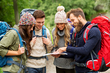 Image showing friends or travelers hiking with backpacks and map