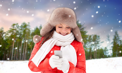 Image showing happy woman with smartphone in winter