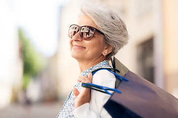 Image showing senior woman in sunglasses with shopping bags