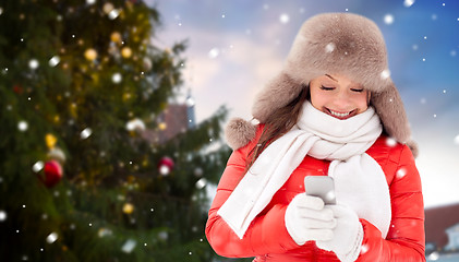 Image showing woman with smartphone over christmas tree