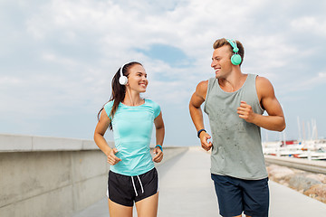 Image showing couple with headphones running outdoors