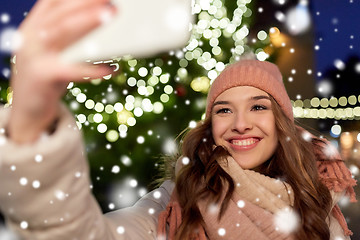 Image showing young woman taking selfie over christmas tree