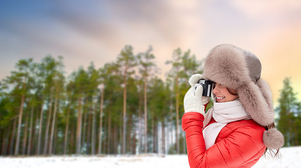 Image showing happy woman with film camera over winter forest