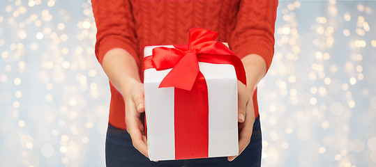 Image showing close up of woman in red sweater holding gift box