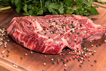 Image showing steak of beef on a wooden board with spices and parsley