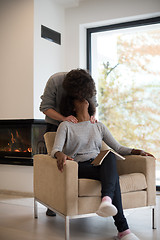 Image showing multiethnic couple hugging in front of fireplace