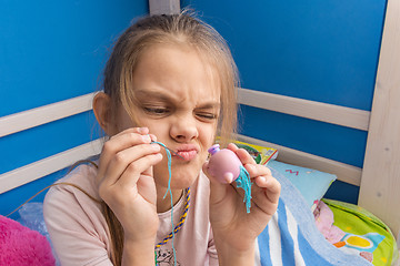 Image showing Funny girl trying to fix a toy