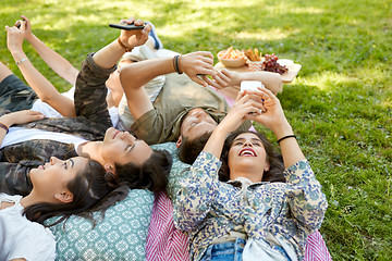 Image showing friends with smartphones chilling at summer park