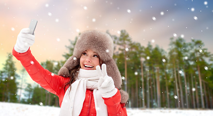 Image showing happy woman taking selfie over winter forest