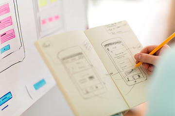 Image showing ui designer with user interface sketch in notebook