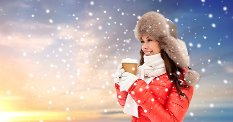 Image showing woman in winter fur hat with coffee over snow