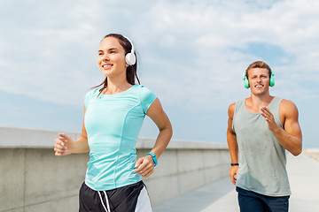 Image showing couple with headphones running outdoors