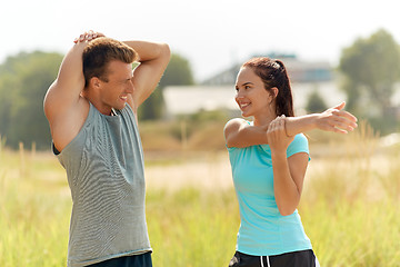 Image showing smiling couple stretching outdoors