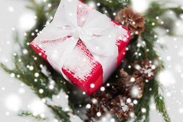 Image showing close up of christmas gift and fir wreath on snow