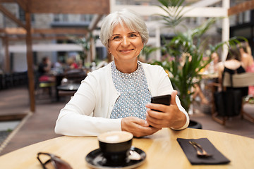 Image showing happy senior woman with smartphone at street cafe