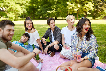 Image showing happy friends with drinks at picnic in summer park