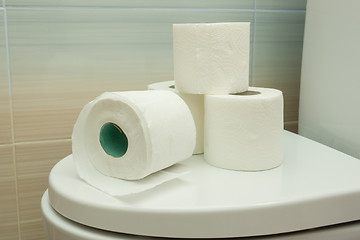 Image showing Several rolls of toilet paper are on the toilet lid
