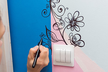 Image showing The artist paints the walls of the children\'s room pattern