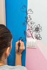 Image showing The artist paints a marker patterns on the walls of the children\'s room