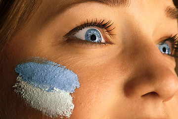 Image showing Portrait of a woman with the flag of the Argentina painted on her face.